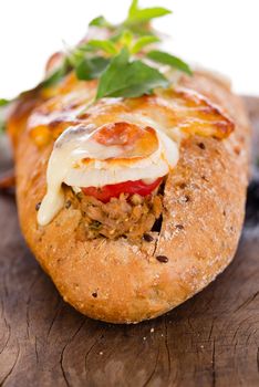 pizza baguette with mozzarella onion and tuna decorated with basil leafs