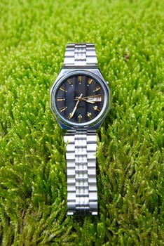 Man's watch on the grass field.