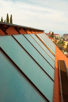 Solar water heating system (geliosystem) on the red house roof.