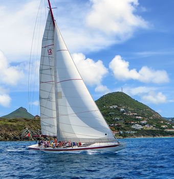 Great Bay, St. Maarten, Netherlands Antilles-June 22, 2013: Former America's Cup yacht, Canada 2, picks up wind and gives the the tourists and crew a thrilling cruise off the coast.