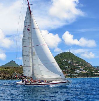 Great Bay, St. Maarten, Netherlands Antilles-June 22, 2013: Former America's Cup yacht, Canada 2, picks up wind and gives the the tourists and crew a thrilling cruise off the coast.