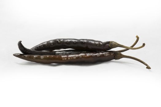 dried black chili peppers on white background