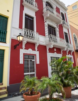 San Juan, Puerto Rico- June 16, 2013: A typical street in Old San Juan with colorful homes and buildings with balconies and potted plants on the street.