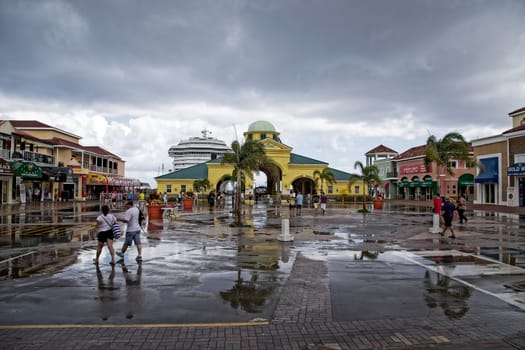Basseterre, Saint Kitts and Nevis- June 21, 2013: Cruise ship passengers head back through the arches at Port Zante after a large downpour on this small Caribbean island.