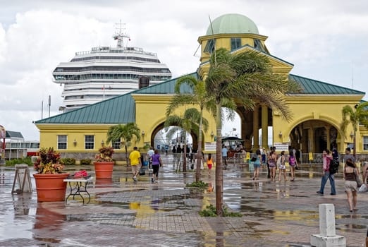 Basseterre, Saint Kitts and Nevis- June 21, 2013: Cruise ship passengers head back through the arches at Port Zante after a large downpour on this small Caribbean island.