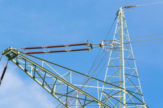 High voltage towers with blue sky in the background.