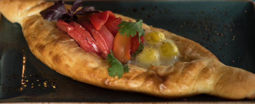 Georgian dish khachapuri and fresh vegetables close-up 