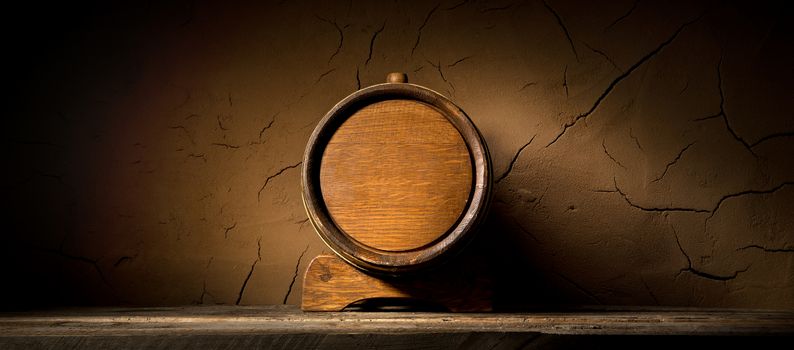 Wooden cask near clay wall in cellar