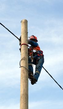 electrician installs insulated wire for electric main with the use of special tools