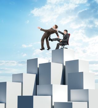 Businessman sitting on chair and kicking man fron pile of boxes