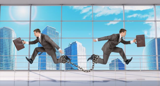 Two businessmen linked chain running in different directions on window view background