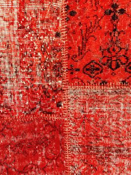 Vintage style red patchwork rug with ethnic design.