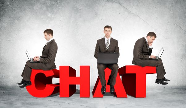 Set of businessmen working on laptop and sitting on word chat on grey wall background