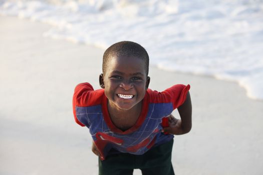 Zanzibar, Tanzania - January 9, 2016: Little cheerful African boy on the beach posing for photos Nungwi. Zanzibar
