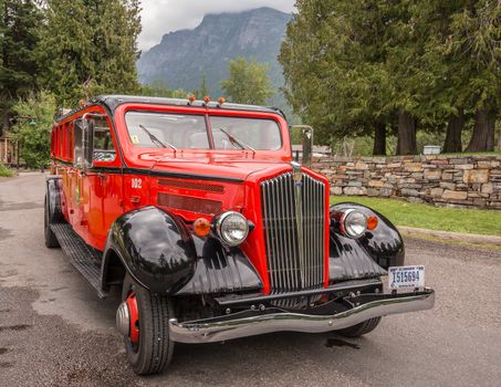 Glacier National Park, Montana, USA-July 11, 2015: The famous Red Bus vehicles of the parks service await passengers to tour Going to the Sun Road inside the park.