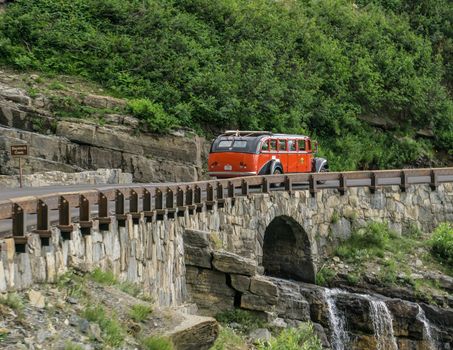 Glacier National Park, Montana, USA-July 11, 2015: The famous Red Bus vehicle of the parks service takes  passengers up to  tour Going to the Sun Road inside the park.