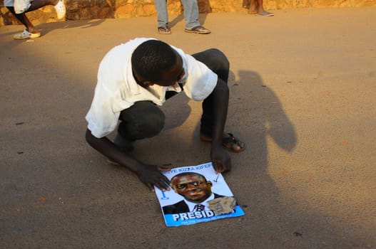 UGANDA, Entebbe: A supporter of Kizza Besigye, Uganda's leading opposition leader and presidential candidate, holds a magazine with a photo of Kizza Besigye after an election rally in Entebbe, Uganda, on February 11, 2016. Besigye will challenge incumbent President Yoweri Museveni for the fourth time when voters go to the polls on February 18, 2016.