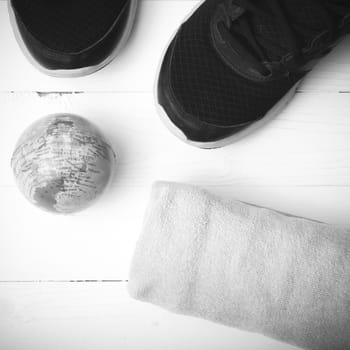 running shoes,towel and earth ball on white wood table concept world healthy black and white tone color style