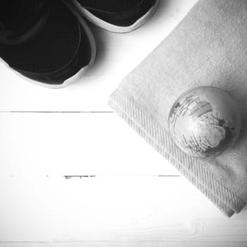 running shoes,towel and earth ball on white wood table concept world healthy black and white tone color style