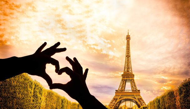 The Eiffel Tower in Paris and hands in a heart shape