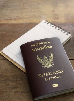 thai passport and notebook on wood table