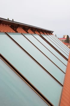 Solar water heating system (geliosystem) on the red house roof.