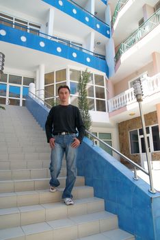 Young man standing on the stairs of modern building