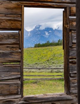 Looking through an old cabin window at the  Grand Tetons National Park, Wyoming.