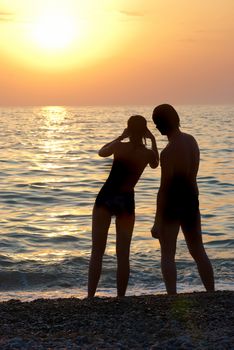 Man, woman and sunset on the sea