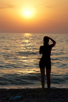 Girl silhouette and sunset on the sea