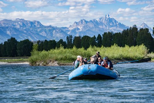 Jackson, Wyoming, USA- July 19, 2015: a group of tourists take a rafting excursion on the Snake River near Jackson, Wyoming. Along the way are numerous eagles and large mammals such as elk that can be spotted from the raftsThe Grand Teton Mountains can be