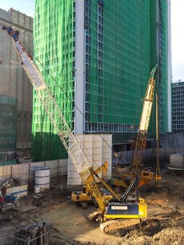 Construction site with crane and worker in progress.