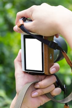 Lady take a photo with camera on her hand.