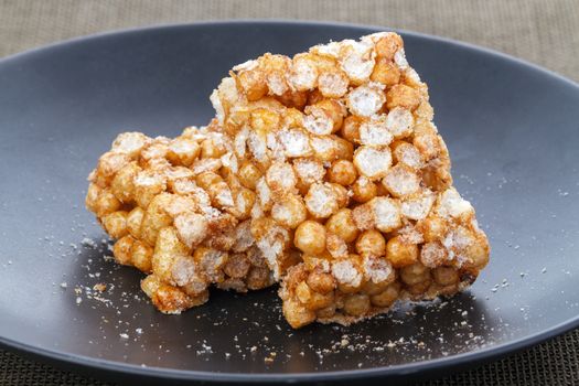 Northern Thai traditional dessert crisp sweet rice ball bar made from sticky rice on black plate
