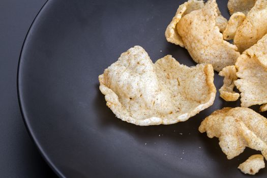 Crisp rice cracker on black plate made from fish, rice, salt, sugar deep-fry