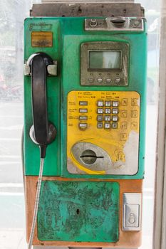 Thai old public phone that say on the left panel 'For coins or card use'.