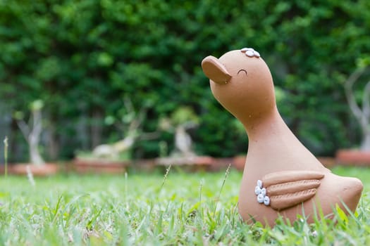 Smiling duck clay doll in the garden