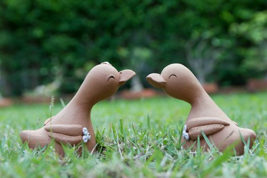 Smiling duck clay doll couple in the garden