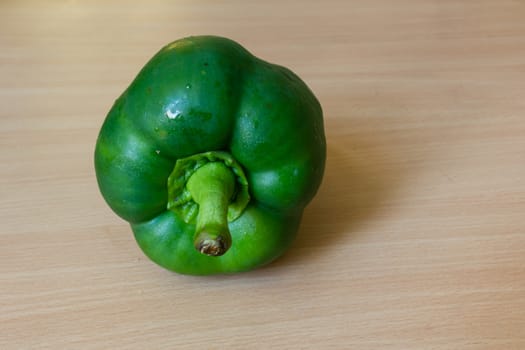 Green pepper on the wooden desk