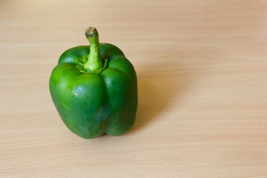 Green pepper on the wooden desk