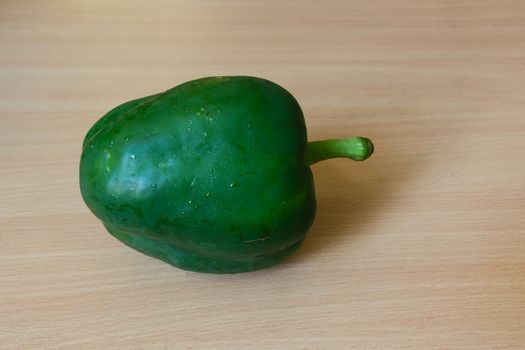 Green pepper (side view) on the wooden desk