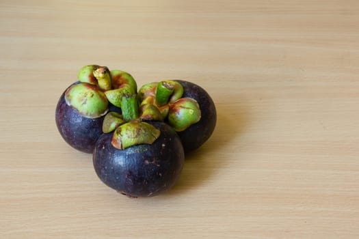 Fresh mangosteen place on a wooden table.