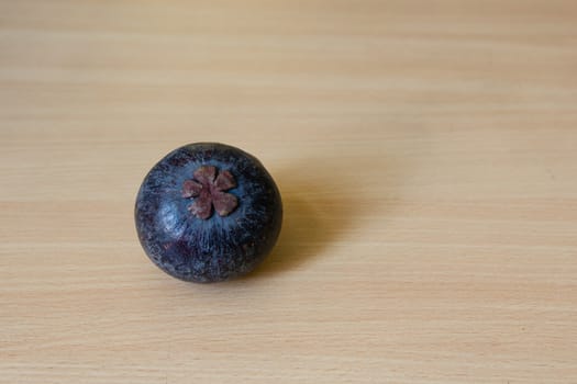 Fresh mangosteen (bottom view) place on a wooden table.