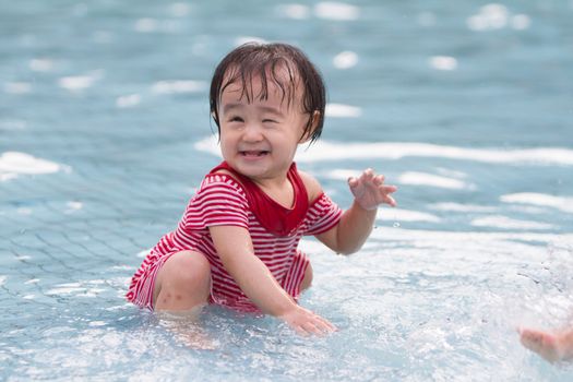 Chinese Little Girl Playing in Water in Swimming Pool