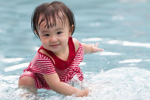 Chinese Little Girl Playing in Water in Swimming Pool