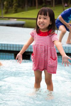 Chinese Little Girl Playing in Water in Swimming Pool