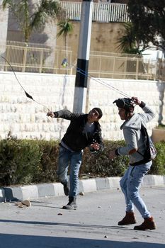 WEST BANK, Bethlehem: Palestinian protesters use slings to hurl stones towards Israeli troops during clashes in the West Bank city of Bethlehem on February 12, 2016. 