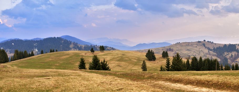 April evening in Carpathian mountains. Spring hills and fields.