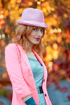 Fashion urban beauty people, smiling woman, outdoor. Playful glamor hipster redhead gir in stylish hat, vivid jacket and gloves. Sunny day, autumn orange bokeh. Creative unusual, park, lifestyle