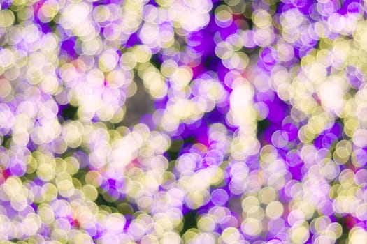 Defocused of glitter or purple and yellow bokeh circle at night as background.